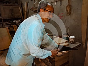 an asian man working at factory on slow lighting in India January 2020