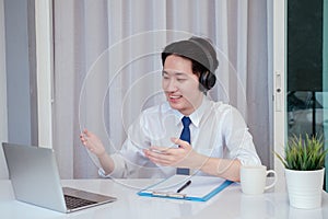 Asian man working from home with laptop computer self isolation from society to reduce risk, quarantine