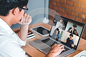 Asian man working from home use Smart working and video conference online meeting with Asian team using laptop and tablet online