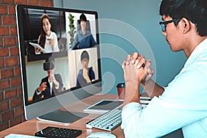 Asian man working from home use Smart working and video conference online meeting with Asian team using laptop and tablet online