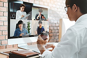 Asian man working from home use Smart working and video conference online meeting with Asian team using laptop and tablet online