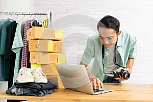 Asian man working laptop computer selling online