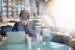 Asian man working with laptop in library