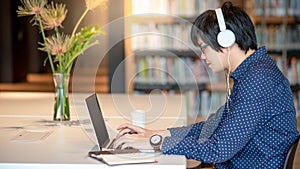 Asian man working with laptop in library