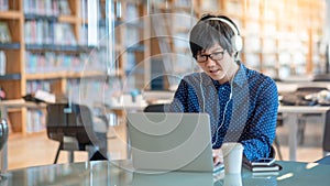 Asian man working with laptop in library