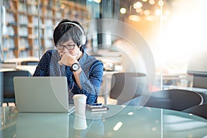 Asian man working with laptop in library