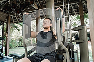 Asian man workout with pec deck machine