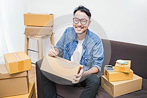 Asian man writing address on the box