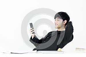 Asian manager businessman sitting at desk and using with phone,