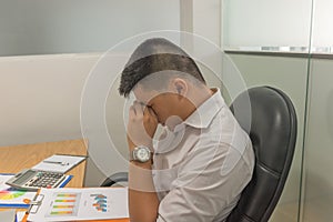 Asian manager exhausted and frustrated after checking many sales reports