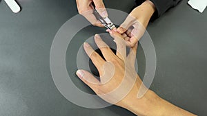 Asian manicurist woman cutting a customer\'s nails