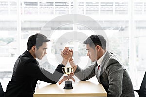 Asian mans with arm wrestle with trophy competition / business competition / winner photo