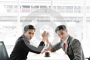 Asian mans with arm wrestle with trophy competition / business competition / winner photo