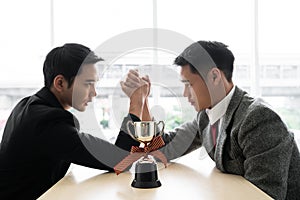 Asian mans with arm wrestle with trophy competition / business competition / winner photo