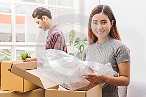 Asian married couple start new family life concept. Woman and man unpacking messy boxes after moving in new house together