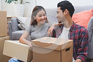 Asian married couple start new family life concept. Woman and man unpacking messy boxes after moving in new house together