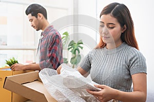 Asian married couple start new family life concept. Woman and man unpacking messy boxes after moving in new house together