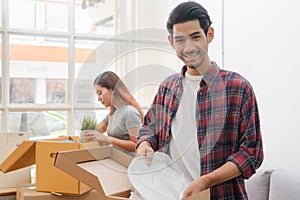 Asian married couple start new family life concept. Woman and man unpacking messy boxes after moving in new house together