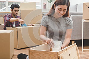 Asian married couple start new family life concept. Woman and man unpacking messy boxes after moving in new house together
