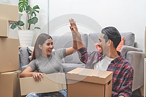 Asian married couple start new family life concept. Woman and man unpacking messy boxes after moving in new house together