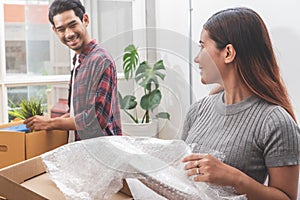 Asian married couple start new family life concept. Woman and man unpacking messy boxes after moving in new house together