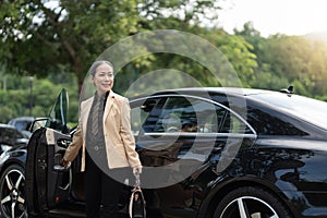 Asian mature business success woman disembarking the luxury car