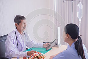 Asian mature male doctor. Smiling, Doctors giving a consultation Explain the medical to patient