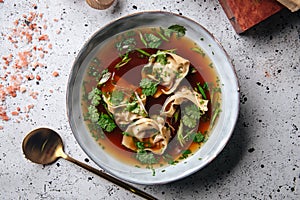 Asian meat stuffed dumplings with bouillon in bowl