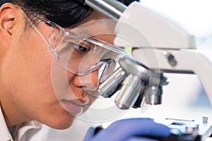 Asian medical doctor working in research lab. Science assistant making pharmaceutical experiments. Chemistry, medicine