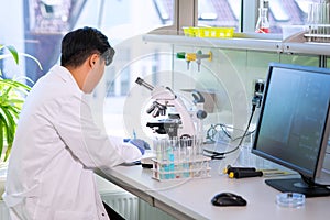 Asian medical doctor working in research lab. Science assistant making pharmaceutical experiments. Chemistry, medicine