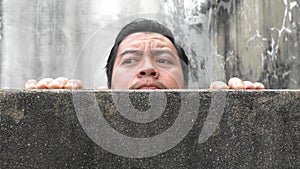 Asian men climb up concrete walls