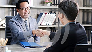 Asian men handshake successfully in job interview at office background, job search, business concept