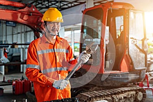 Asian men with large iron wrench in a hand, Powerful Professional Mechanic. Heavy Duty Equipment Maintenance. Industrial Concept