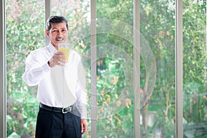 Asian men Retirement age Healthy Beaming Holding a glass of orange juice
