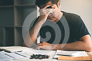 Asian men are stressed about financial problems, with invoices and calculators placed on the table while having stress on problems