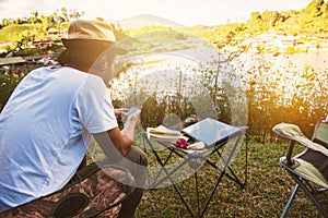 Asian men are using the phone to search for tourist information, Travel nature, Travel relax, Concept of Camping Relaxing Tourism