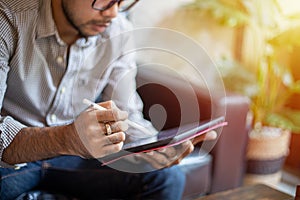 Asian men using tablet for woring at coffee care