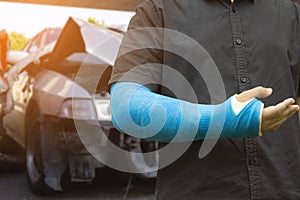 Asian men wear cloth splint on arm to treat car accident injuries