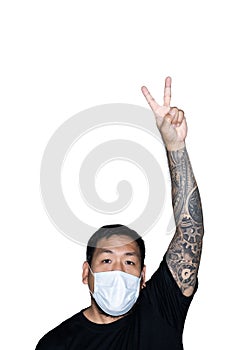 Asian men is wear a medical mask and showing a hand with victory sign in white background with copy space above.The concept of