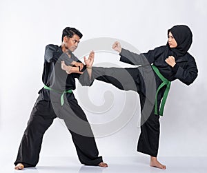 Asian men and women wearing pencak silat uniforms fight