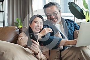 Asian Middle-aged Asian couple in living room at home.