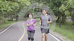 Asian middle aged couple jogging and running in park