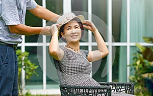 Asiatico medio vecchio rilassarsi Giardino dietro la casa un introduzione sul un cappello sul il suo moglie 