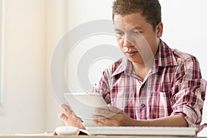 Asian middle aged man reading ebook in touchpad