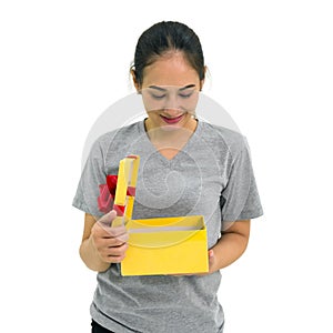 Asian middle-aged woman in gray t-shirt enjoy opening a gift box received for a special occasion. Portrait on white background