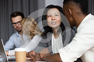 Asian middle-aged woman mentor teach African guy millennial intern