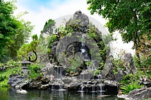 Asian miniature landscape of bizzare rock formation and waterfall in Thien Mu Pagoda garden, City of Hue, Vietnam