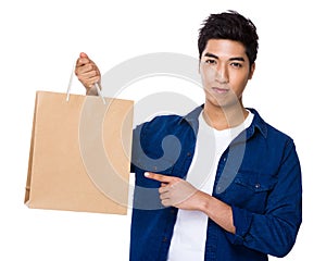 Asian mixed Indian man finger point to shopping bag