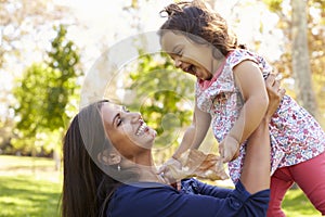 Asian mixed race mum and young daughter playing in park