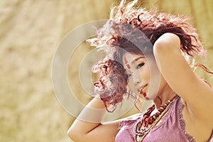 Asian model with make-up on face in feulette dress against haystack background